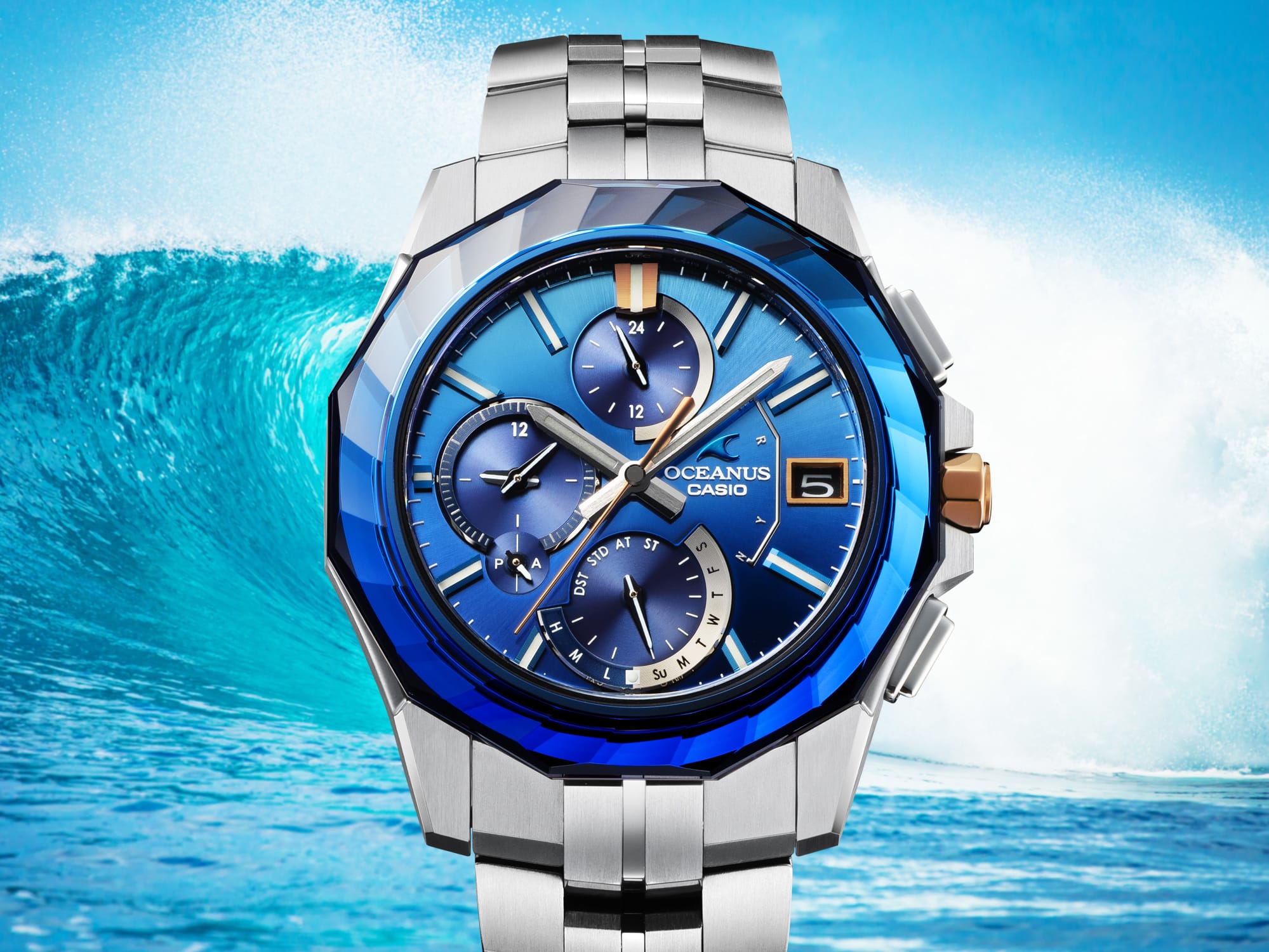 OCEANUS OCWS6000SW-2A Analog watch with blue face and bezel in front of a wave