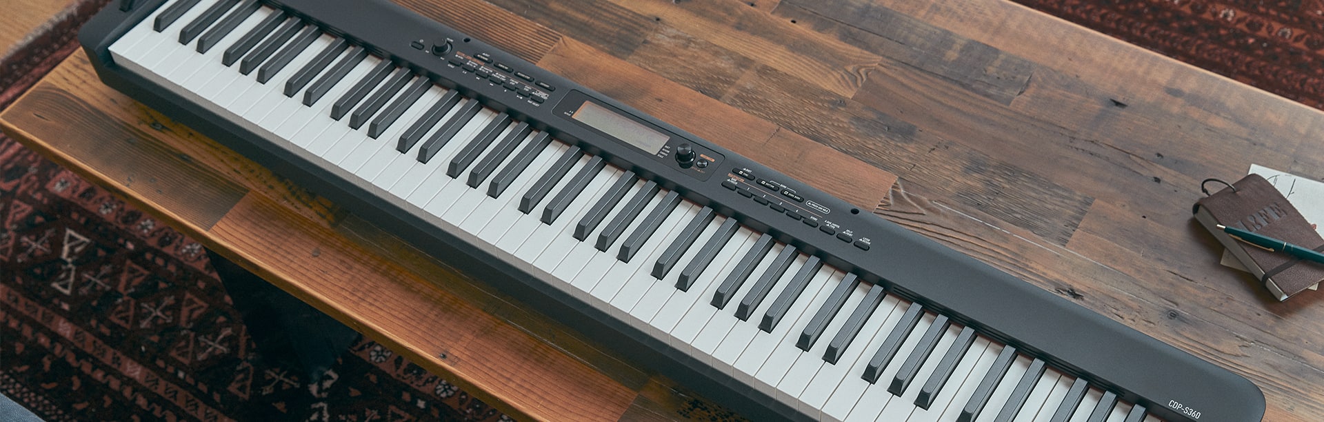 Angled top-down view of a Casio CDP-S360 digital piano on a coffee table 2